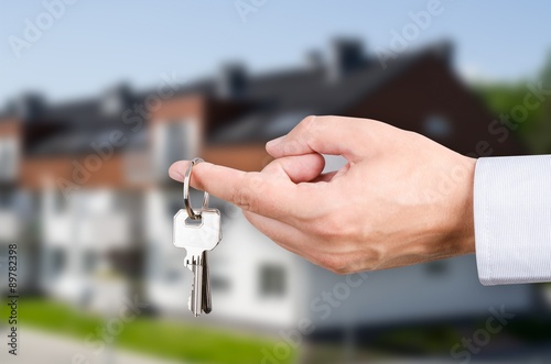 Man hand holding keys with to new house