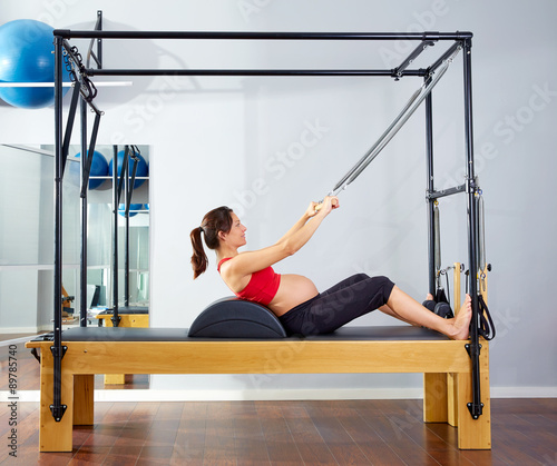 pregnant woman pilates reformer roll up exercise