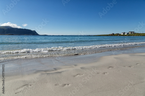 Footstep in the sand on a beach with some waves rolling in