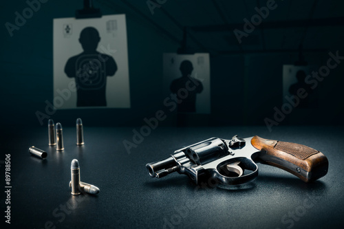 gun sitting on a table at a shooting range / dramatic lighting photo