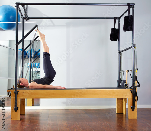 Pilates woman in reformer tower exercise at gym