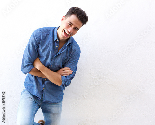 Cheerful young man in blue shirt laughing © mimagephotos