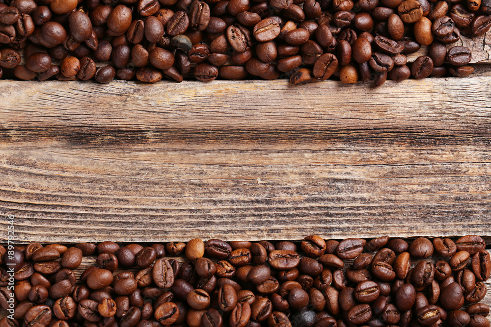 Roasted coffee beans on a brown wooden background Roasted coffee beans on a brown wooden background
