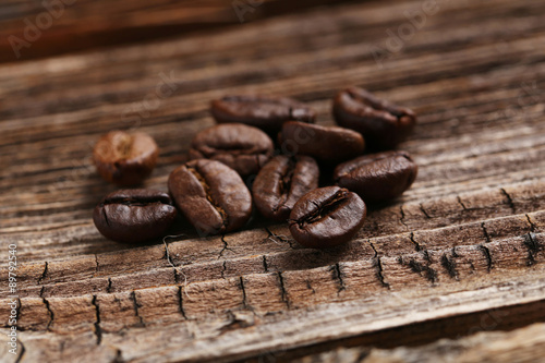 Roasted coffee beans on a brown wooden background