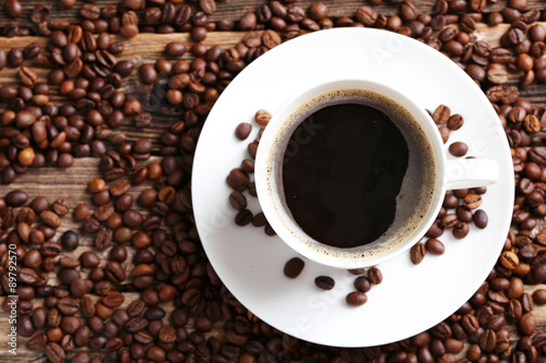 Cup of coffee with coffee beans on a brown wooden background © 5second