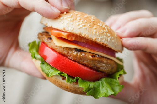 Appetizing burger in male hands