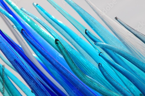 Detailled view of blue glass tubes with white background