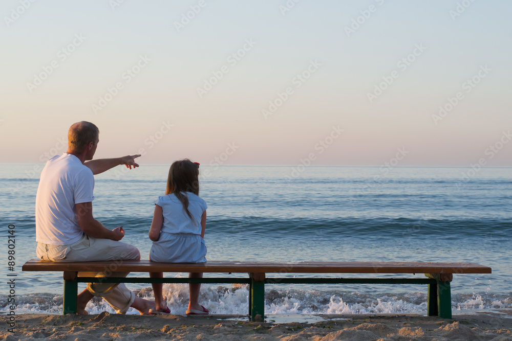 father and daughter looking at the sea