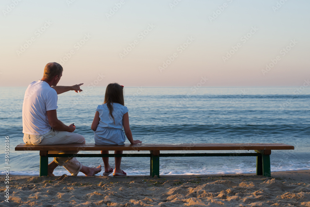 father and daughter looking at the sea
