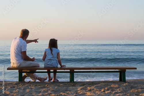 father and daughter looking at the sea