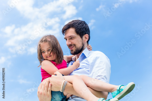 Vater trägt Tochter auf den Händen und beschützt sie