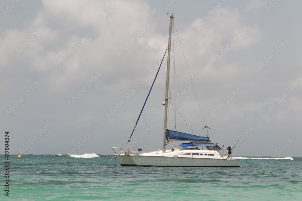 White catamaran on azure water against blue sky, Caribbean Islands White catamaran on azure water against blue sky, Caribbean Islands