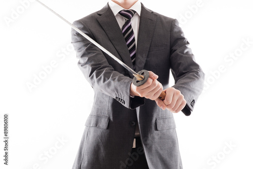 日本刀を持っているスーツのビジネスマン