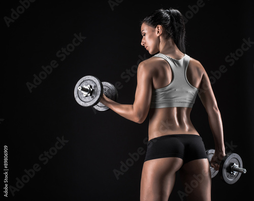 Young woman lifting the dumbbells #89806909