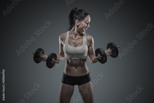 Young woman lifting the dumbbells #89806956