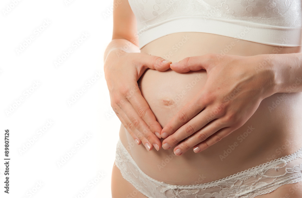Pregnant Woman holding her hands in a heart shape on her baby bump