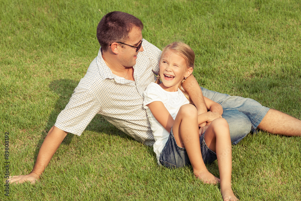 Father and daughter playing on the grass at the day time. Father and daughter playing on the grass at the day time.