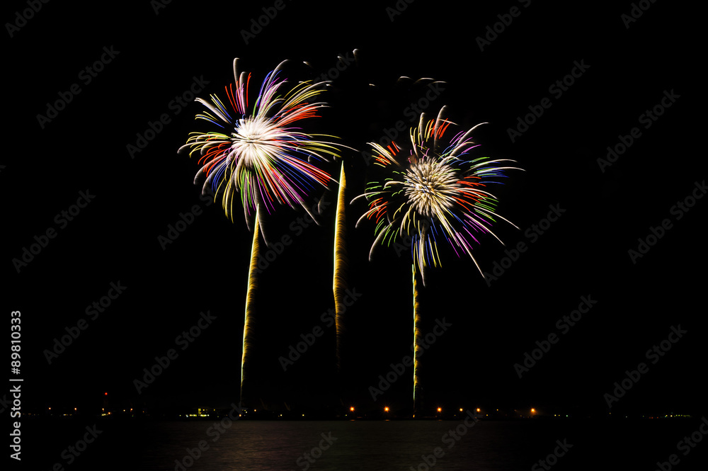 A summer night's fireworks display with beautiful colors against a dark night sky. A summer night's fireworks display with beautiful colors against a dark night sky.