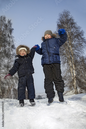 happy boys jump in winter outdoors
