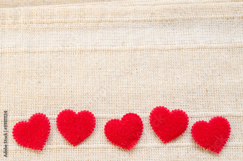 Red heart fabric on vintage fabric background.