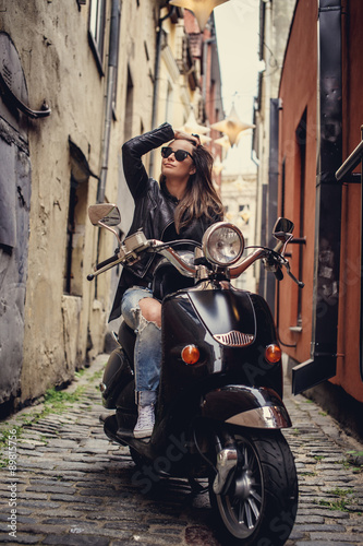 Casual young woman sitting on moto scooter. © Fxquadro