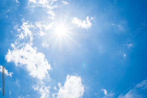 Blue sky with clouds and sun.