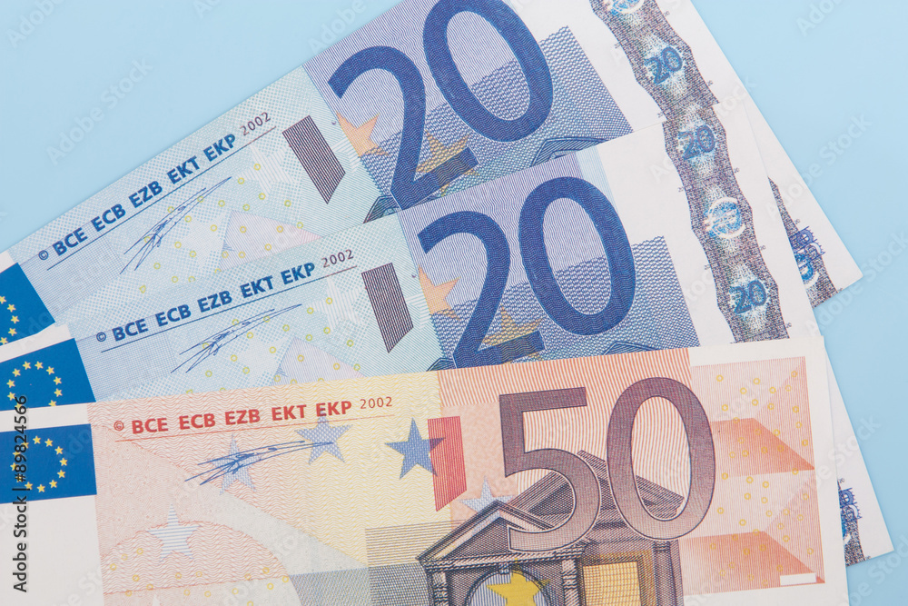 Ninety euro in various notes on light blue background Ninety euro in various notes on light blue background