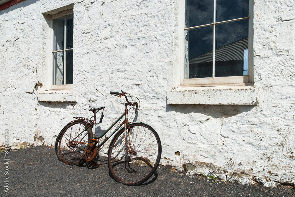 Broken old bicycle leaning against old building Broken old bicycle leaning against old building