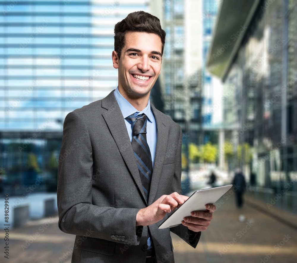 Businessman using his tablet in a business environment Businessman using his tablet in a business environment