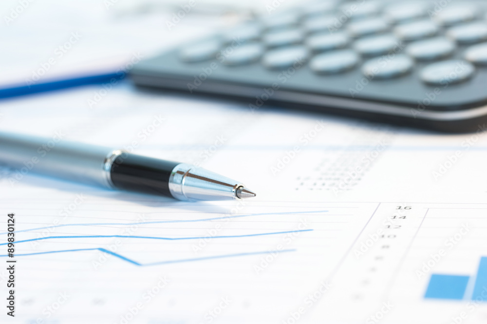 Pen and calculator over business documents Pen and calculator over business documents