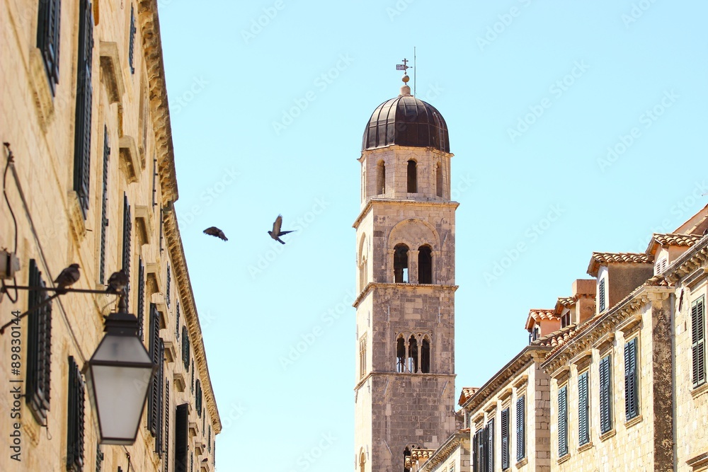 Bell tower in Dubrovnik and pigeons in flight