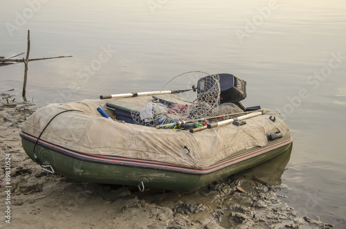Надувная рыбацкая резиновая моторная лодка на берегу реки