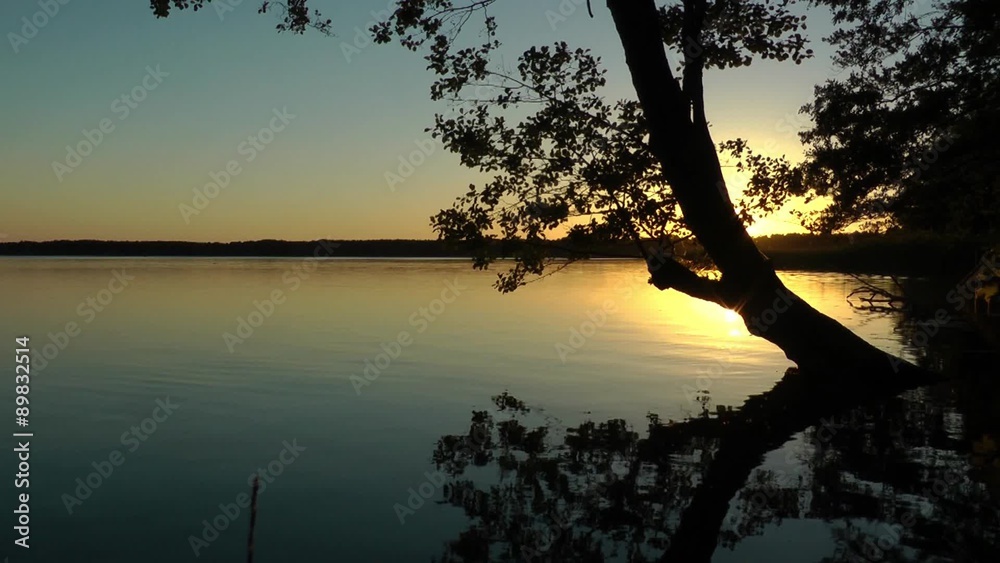 Bad im Sonnenuntergang am See, Baum spiegelt sich die der ruhigen Oberfläche