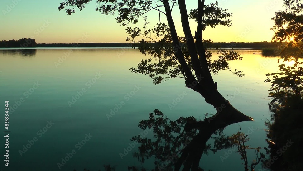 Bad im Sonnenuntergang am See, Baum spiegelt sich die der ruhigen Oberfläche