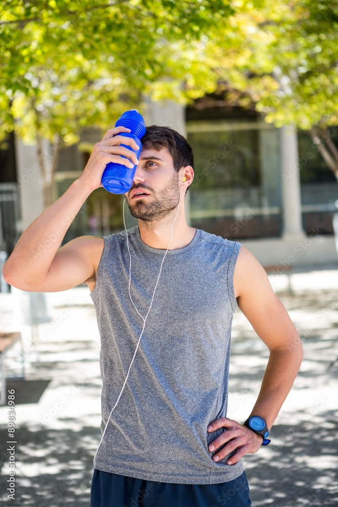 Exhausted runner putting a water bottle on head Exhausted runner putting a water bottle on head