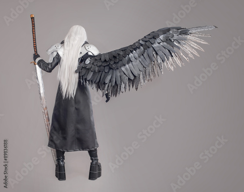 Fantasy woman warrior / Woman warrior with sword and wings isolated on the gray background photo