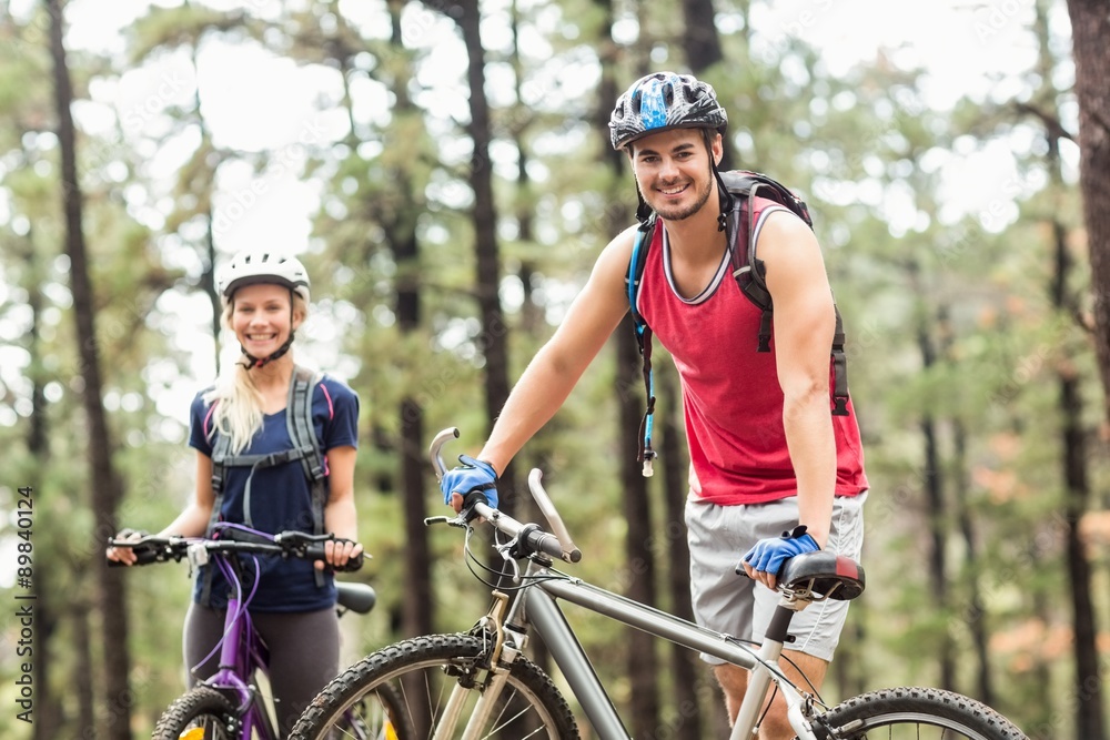 Young happy couple on bikes looking at camera Young happy couple on bikes looking at camera