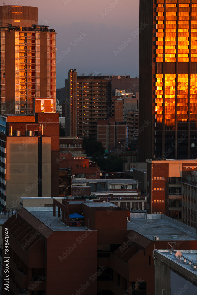 Fototapeta premium Miasto Johannesburg skąpane w popołudniowym słońcu. Zdjęcie budynków i dachów z przedmieść Braamfontein w centrum miasta.