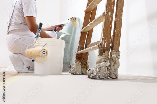painter man at work with a roller, bucket and scale, bottom view