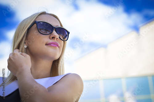 Successful business woman in sunglasses next modern building