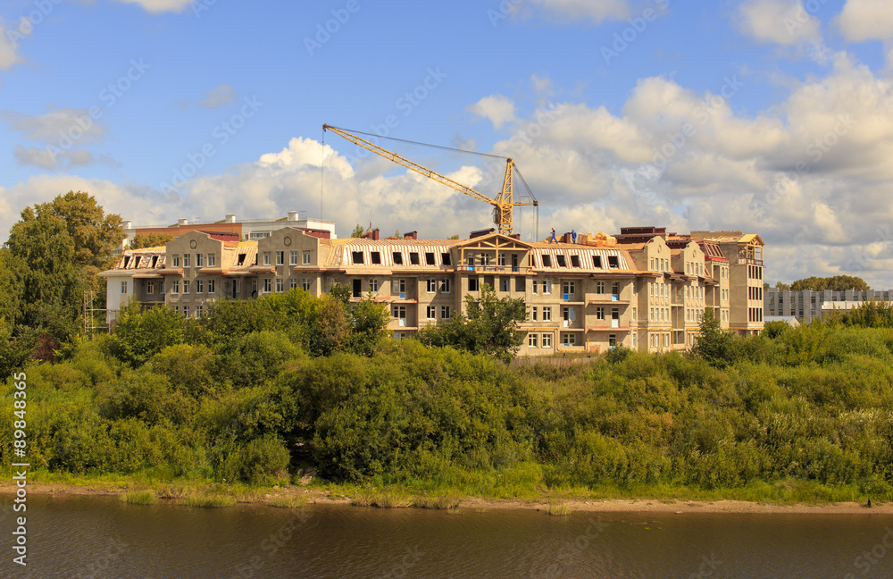 New house by the river. construction of a new apartment house on the river bank