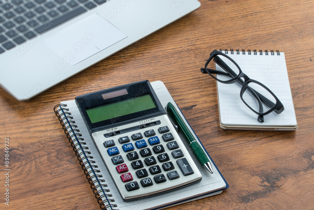 laptop, notebook and pen with calculator on the desk laptop, notebook and pen with calculator on the desk
