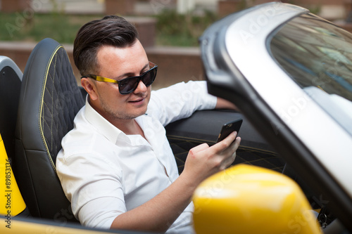 Driver man using smartphone in car © rasstock