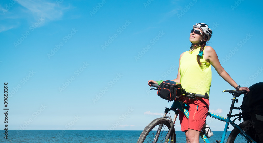 Fototapeta premium Woman with bicycle joyng sun on seaside and smiling