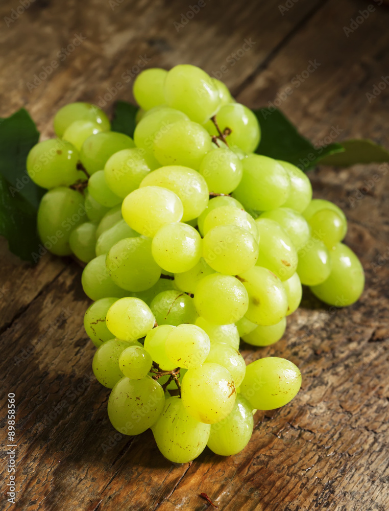 Green grapes on old wooden table, selective focus Green grapes on old wooden table, selective focus