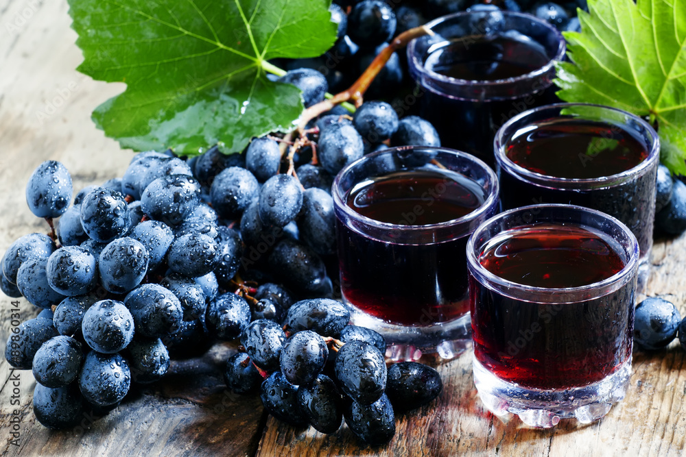 Fresh dark grape juice and fresh berries on old wooden table, se Fresh dark grape juice and fresh berries on old wooden table, se