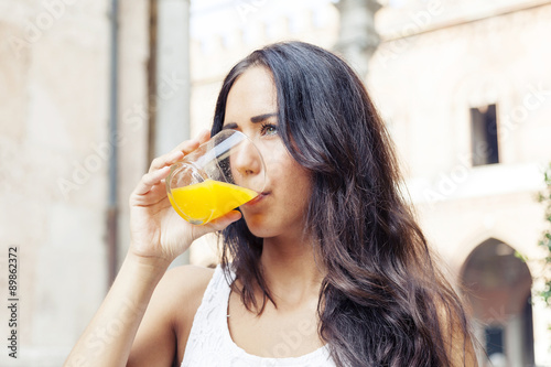portrait of attractive girl while drinking an orange juice