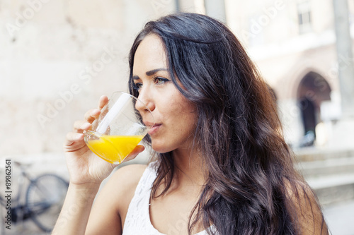 portrait of attractive girl while drinking an orange juice