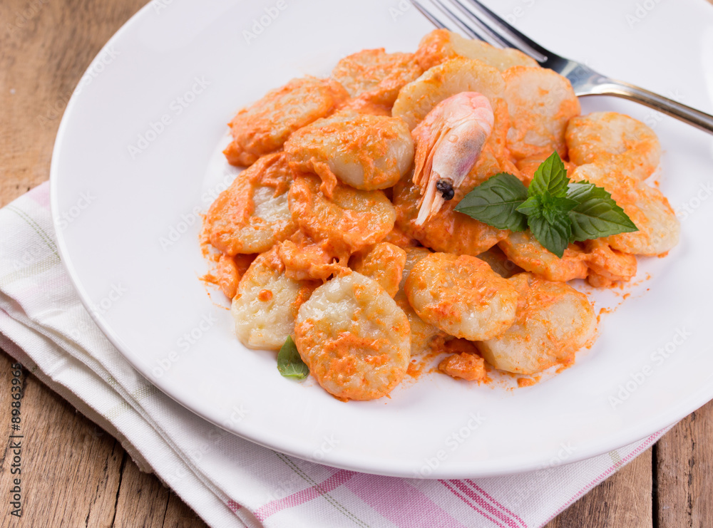 gnocchi with tomato sauce and basil on a tablecloth gnocchi with tomato sauce and basil on a tablecloth