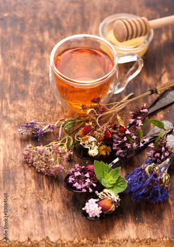 Obraz na plátně Cup of herbal tea with wild flowers and various herbs